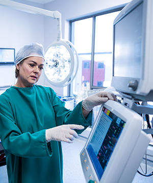 Surgeon in scrubs using a touchscreen medical computer