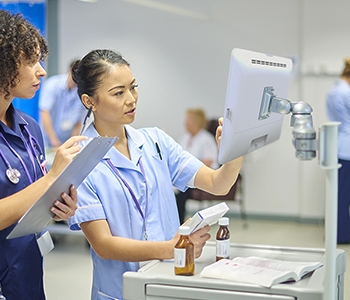 Medizinisches Fachpersonal verwendet einen medizinischen Touchscreen-Computer auf einem Wagen