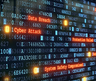 Computer monitor filled with code and highlighted phrases, including Data Breach, Cyber Attack, System Safety Compromised