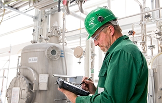 Technician in a manufacturing facility uses a rugged tablet