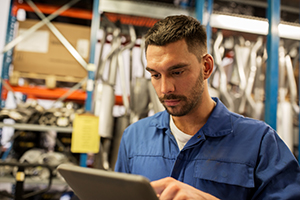 Autoarbeiter mit einem robusten industriellen Tablet-PC in einer Werkstatt