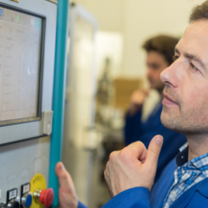 Eine Führungskraft inspiziert einen Industriecomputer in der Fabrikhalle