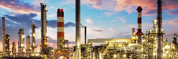 Skyline einer Industriefabrik mit Schornsteinen bei Sonnenuntergang