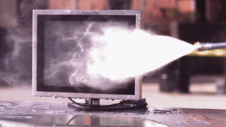 Ein Hochdruckreiniger besprüht die Oberfläche eines Computers.