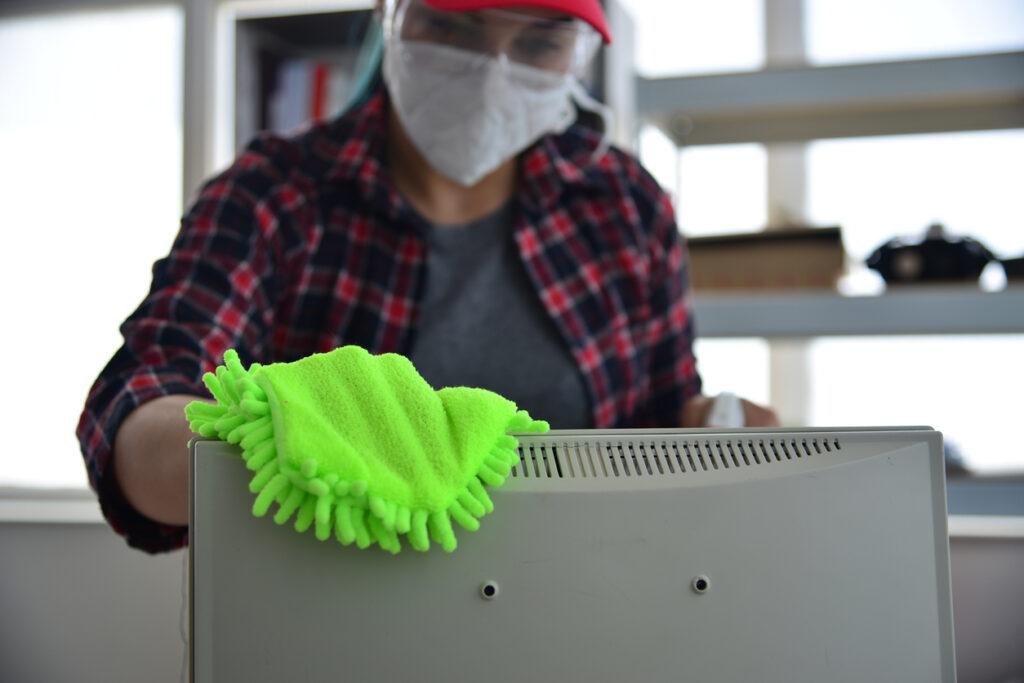 Arbeiter, der einen Computermonitor reinigt