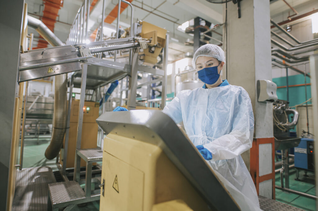 Reinraummitarbeiter im Kittel, der einen wasserdichten Computer bedient