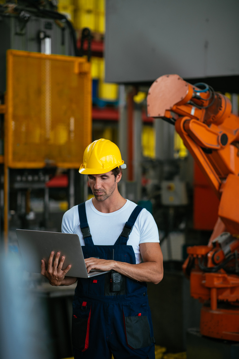 Fabrikarbeiter arbeitet an seinem Laptop im Lager