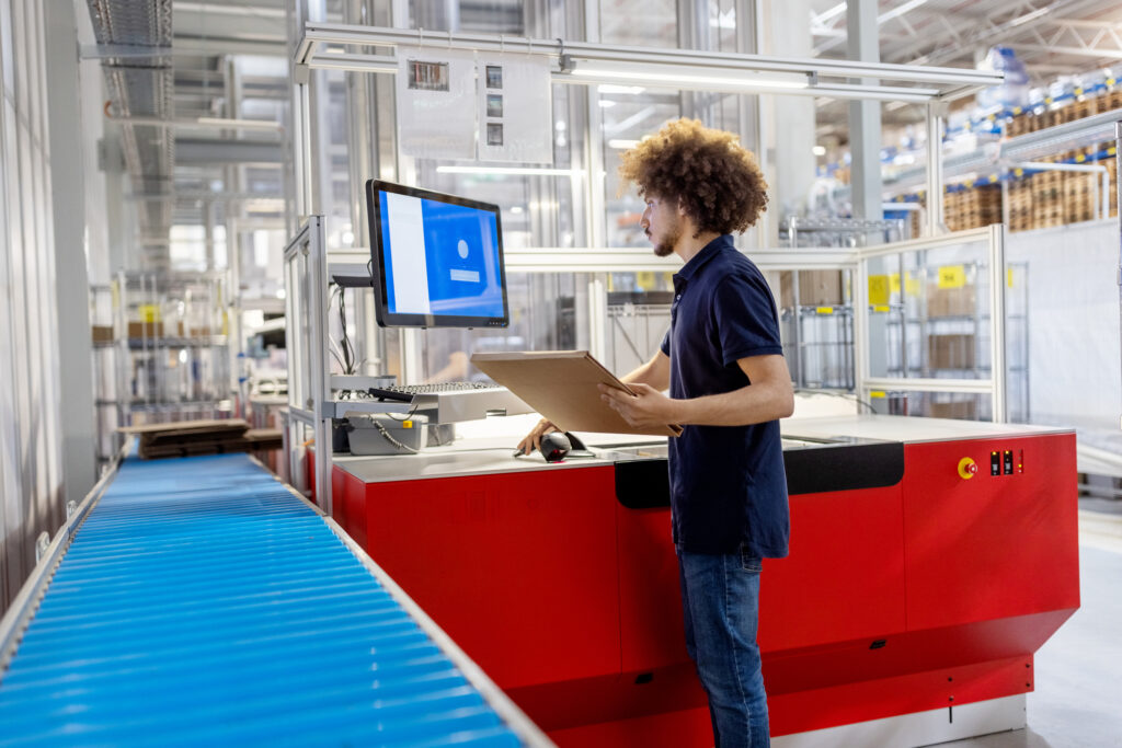ein Mann, der an einem Panel-PC arbeitet, um ein Fließband zu bedienen