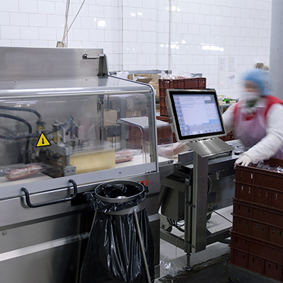 Ein Angestellter bedient Maschinen in der Nähe eines großen Panel-Computers in einem Reinraum.