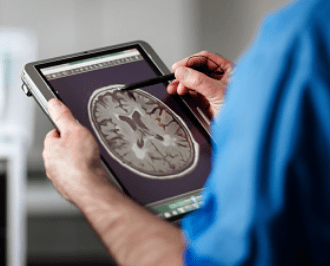 Medical tech uses a medical tablet to examine a scan