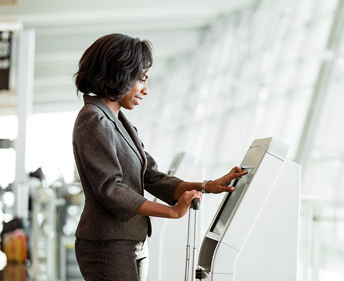 Woman using a public kiosk at an airport
