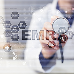 Doctor holding up a stethoscope to a digital display that says EMR