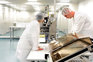 Workers in cleanroom facility use an industrial computer