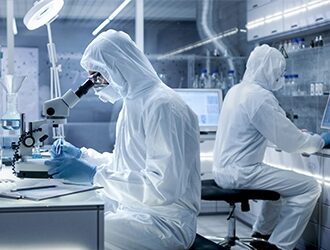 Two lab technicians working in a clean room environment