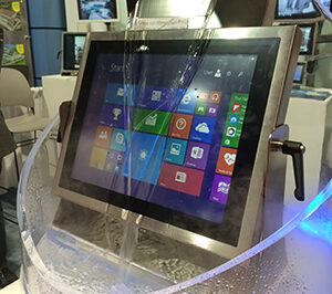Tradeshow display of a Teguar waterproof touchscreen computer being constantly cascaded by water