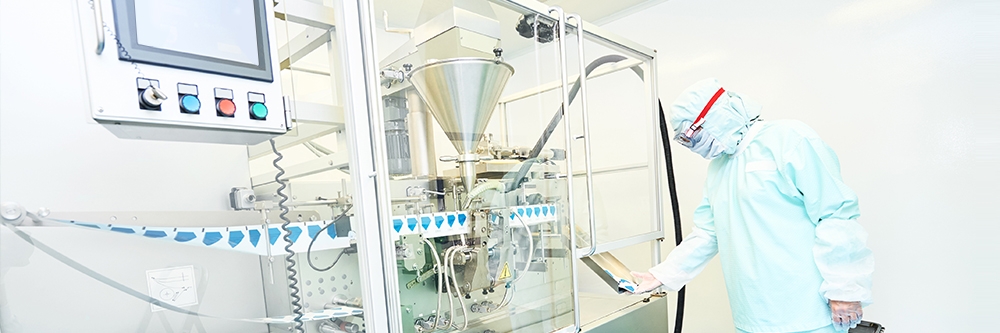 Engineer wearing protective clothing uses manufacturing equipment in a clean room