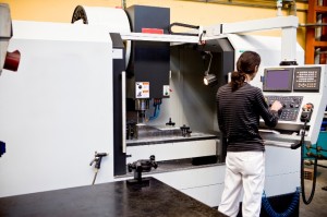 Technician using an industrial computer to operate manufacturing equipment