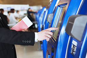Man uses public touchscreen kiosk at the airport