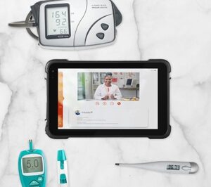 Tablet being used for telehealth while medical instruments surround it