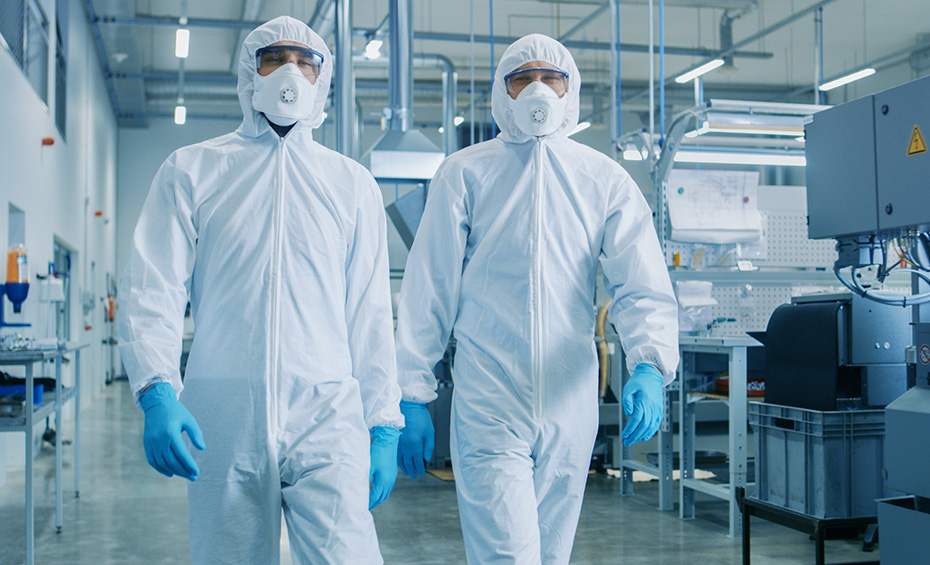 Two engineers in clean room attire walking through a cleanroom