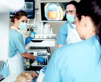 surgeons in an operating theater using a medical computer to operate robotic medical equipment