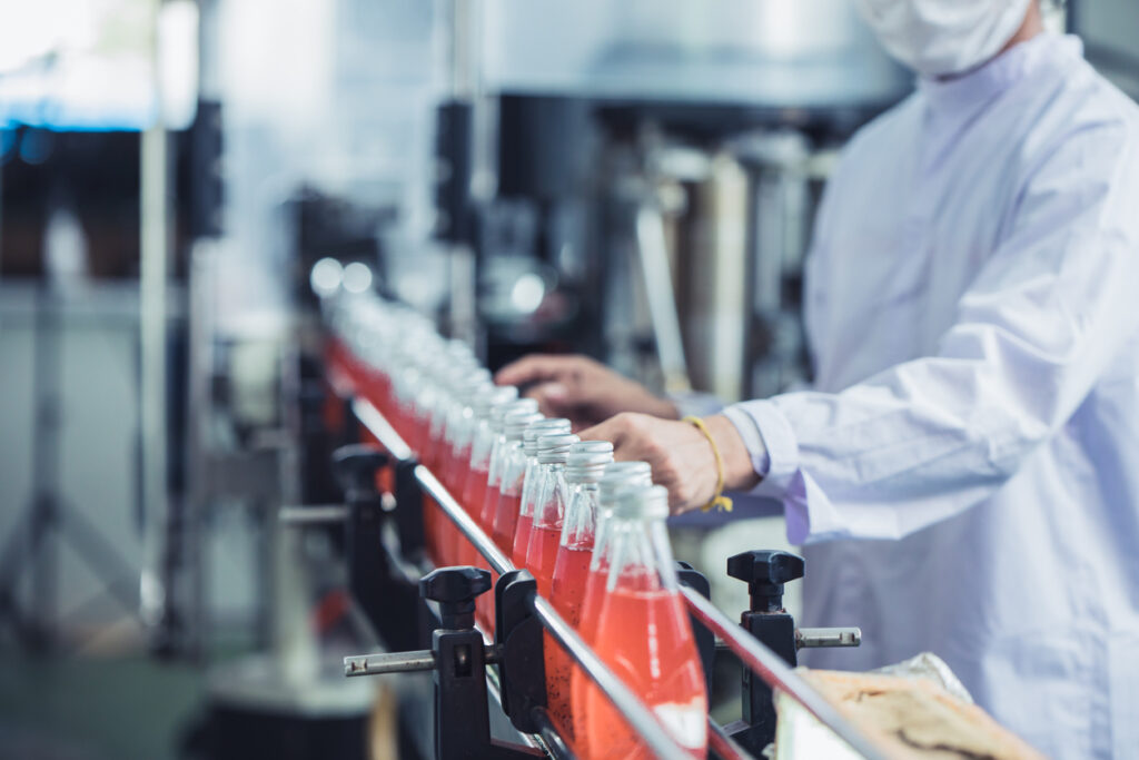 A worker ensuring food and beverage compliance in a bottling factory