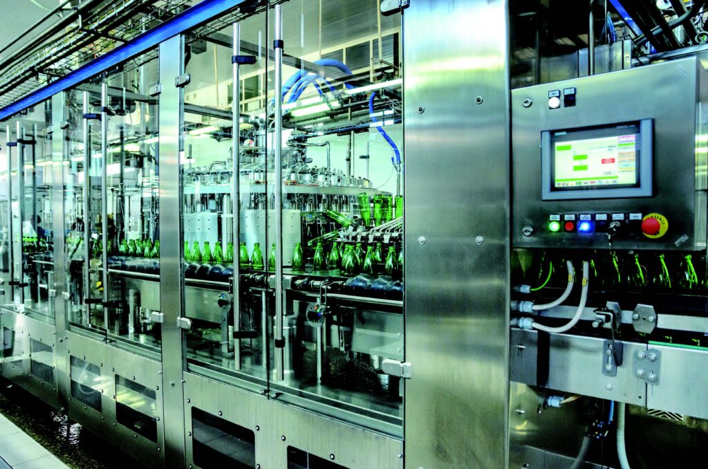 A rugged AI platform PC application example, showing a factory processing beverage bottles. An active industrial computer display is shown in the foreground.