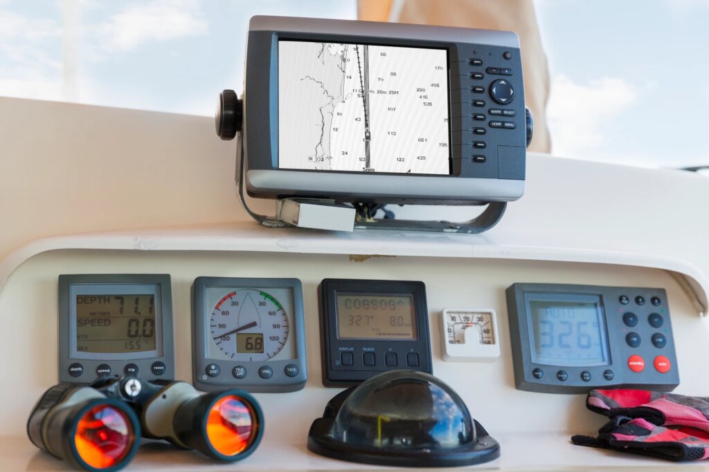The cockpit of a yacht, featuring several computer products and screens.