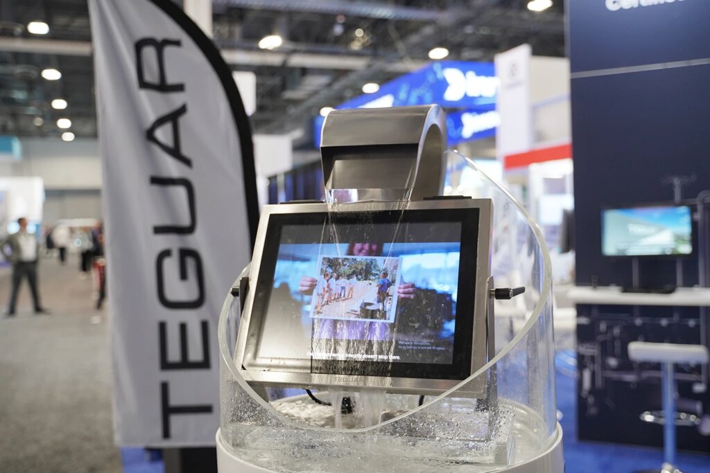 A fountain pours water over a Teguar computer screen as it plays a YouTube video