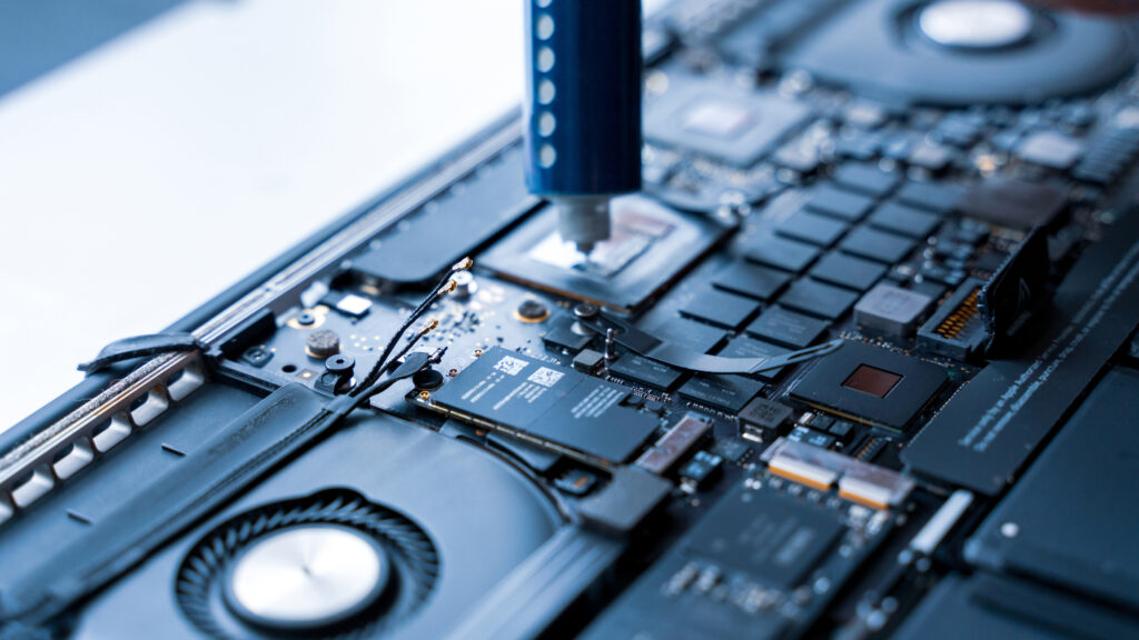 Computer technician service with laptop on hardware background.