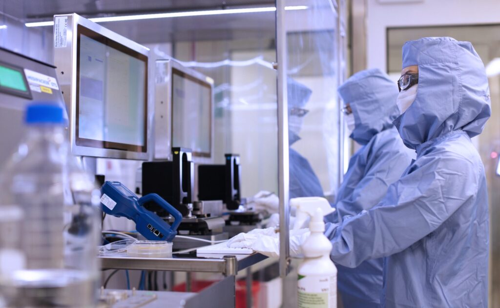technicians working on computers in a pharmaceutical cleanroom