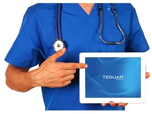 Healthcare professional holding up a Teguar tablet and pointing to the touchscreen