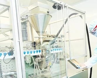 Engineer wearing protective clothing uses manufacturing equipment in a clean room