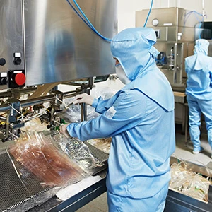 Factory worker in a food processing plant using industrial machinery
