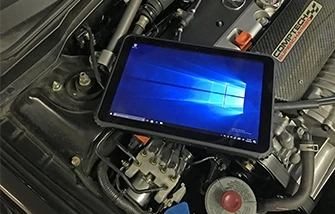 Rugged tablet sitting on top of a motor engine